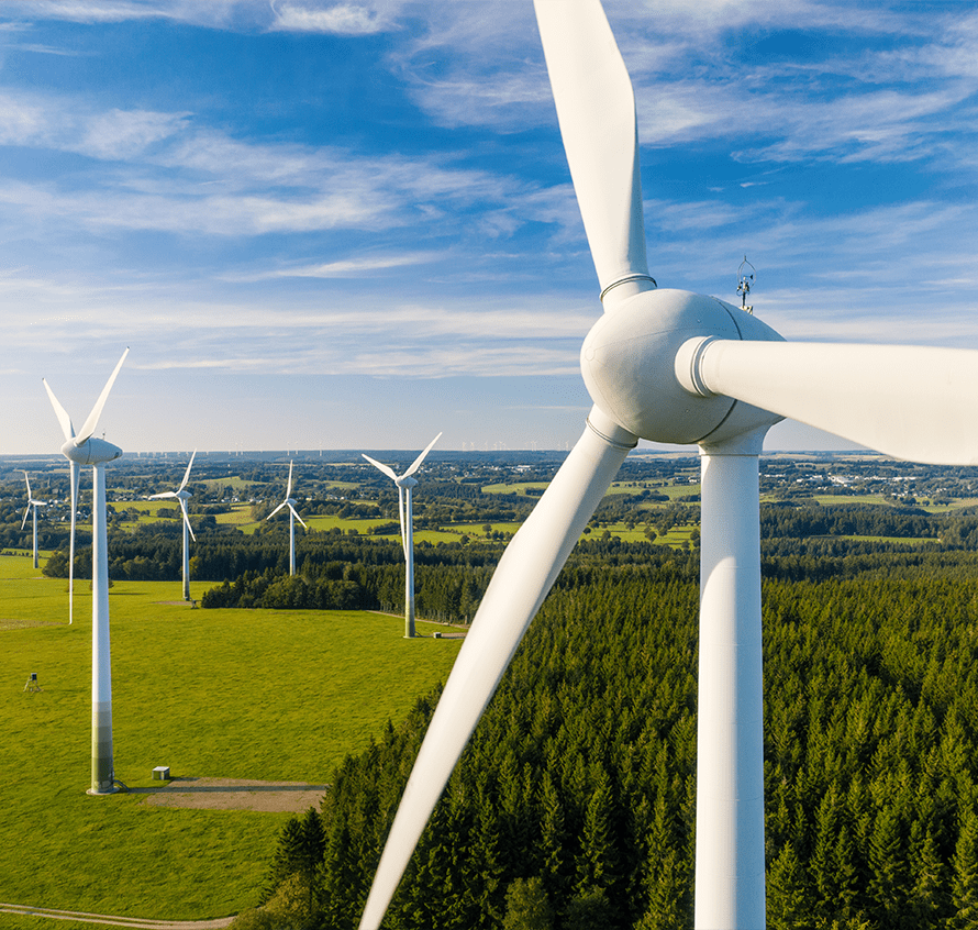 Wind turbines in a green landscape under a blue sky.