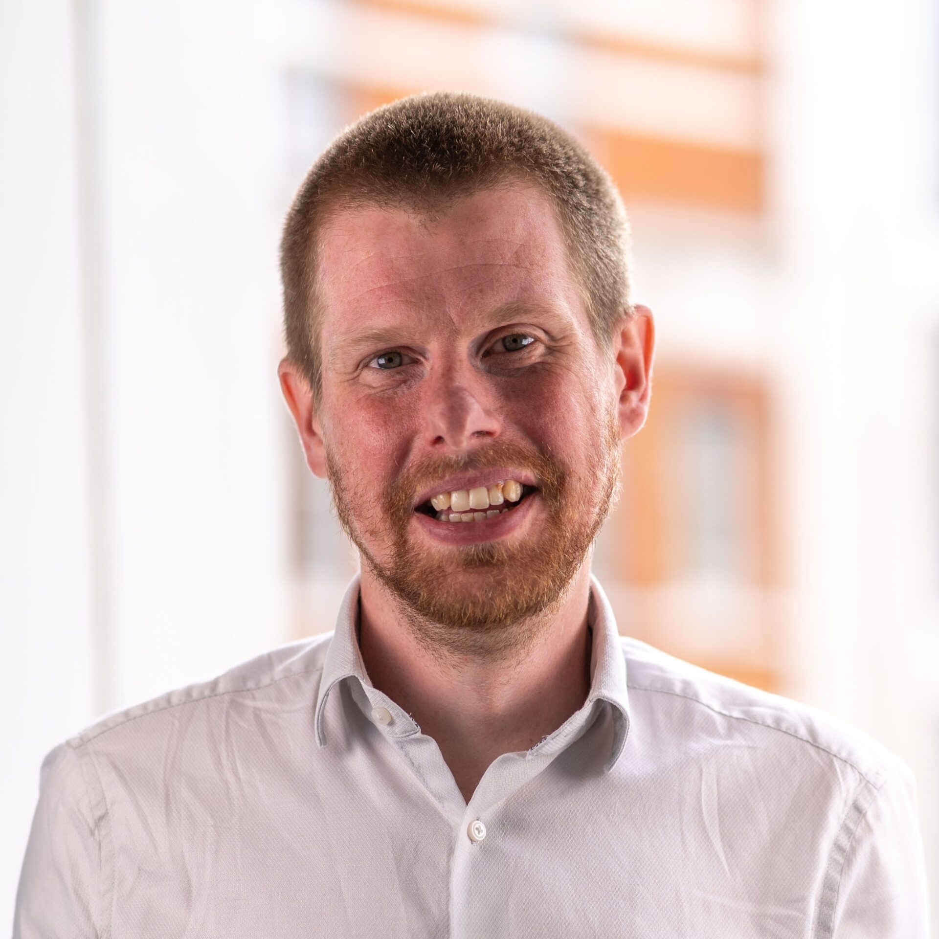 Smiling man with short hair and a beard.