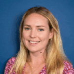 Smiling woman with long blonde hair against a blue background.