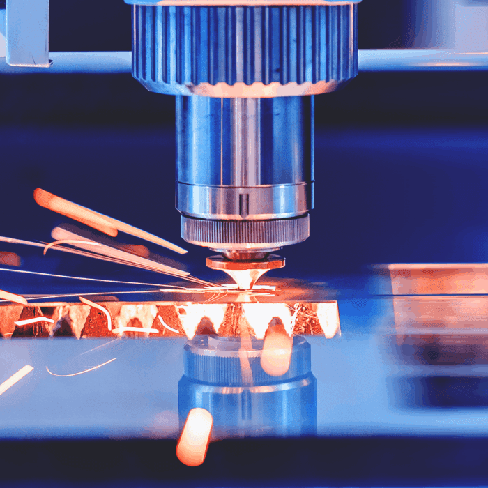 A close-up of a laser cutting machine cutting through metal, sparks flying.