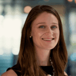 Smiling woman with long hair in a professional setting.