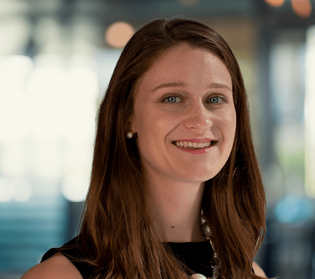Smiling woman with long hair in a professional setting.