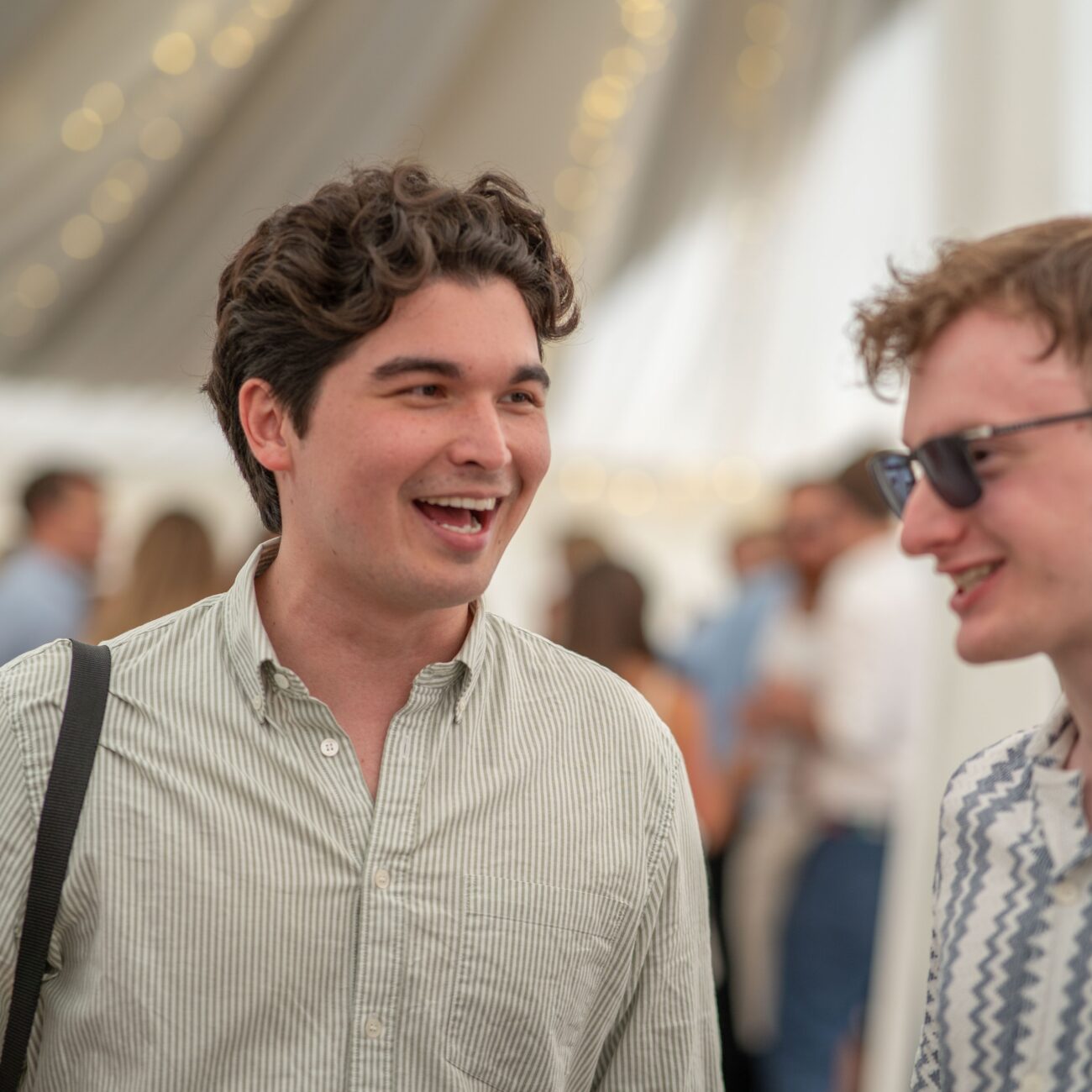 Two young men laughing and chatting indoors.