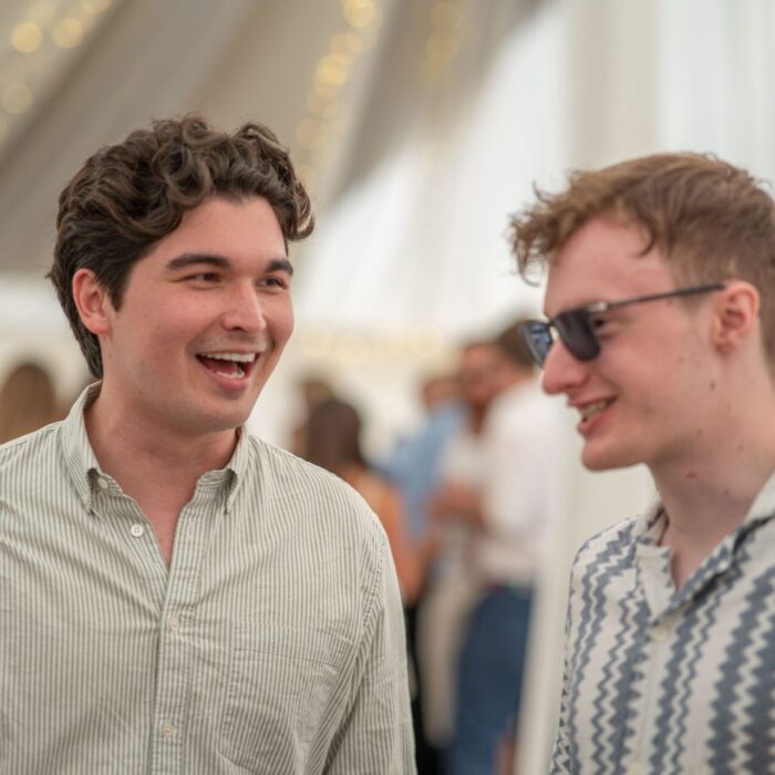 Two young men laughing and chatting indoors.