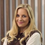 Smiling woman with long blonde hair and a sweater.