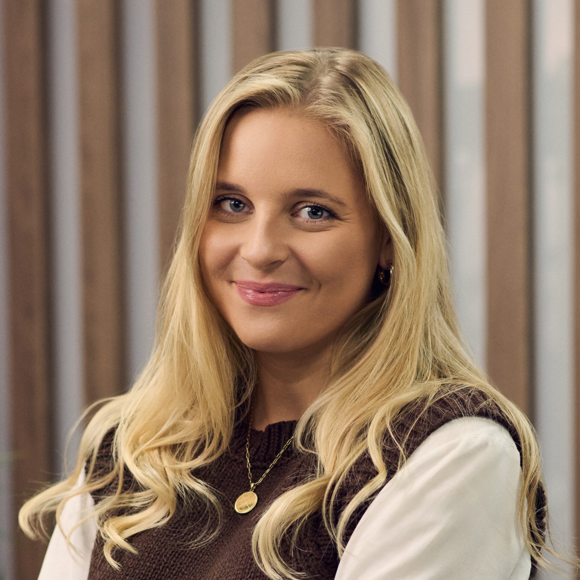Smiling woman with long blonde hair and a sweater.