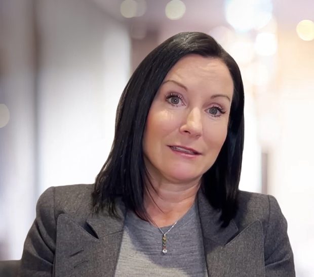Professional woman with shoulder-length black hair speaking.